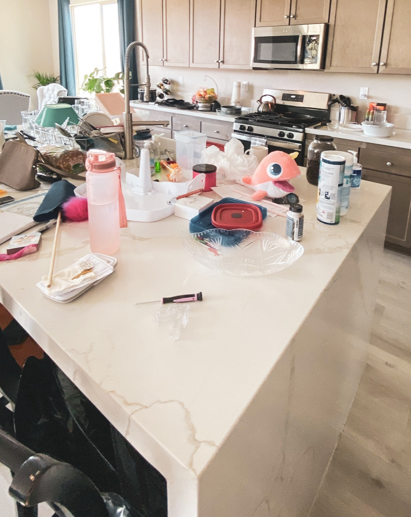 Cluttered kitchen counter with everyday items like dishes, bottles, and mail, representing how clutter can reveal patterns and feedback about daily routines.